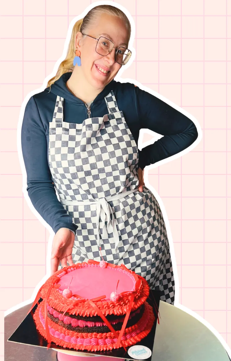 Jessie in een geblokt schort naast een rood-roze taart